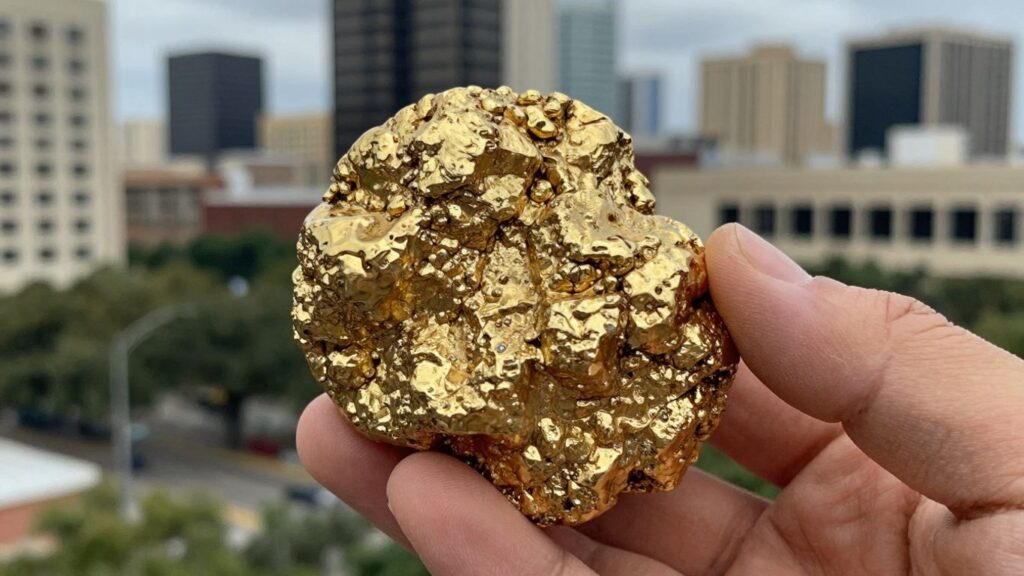 Gold nugget held in hand with San Antonio skyline.