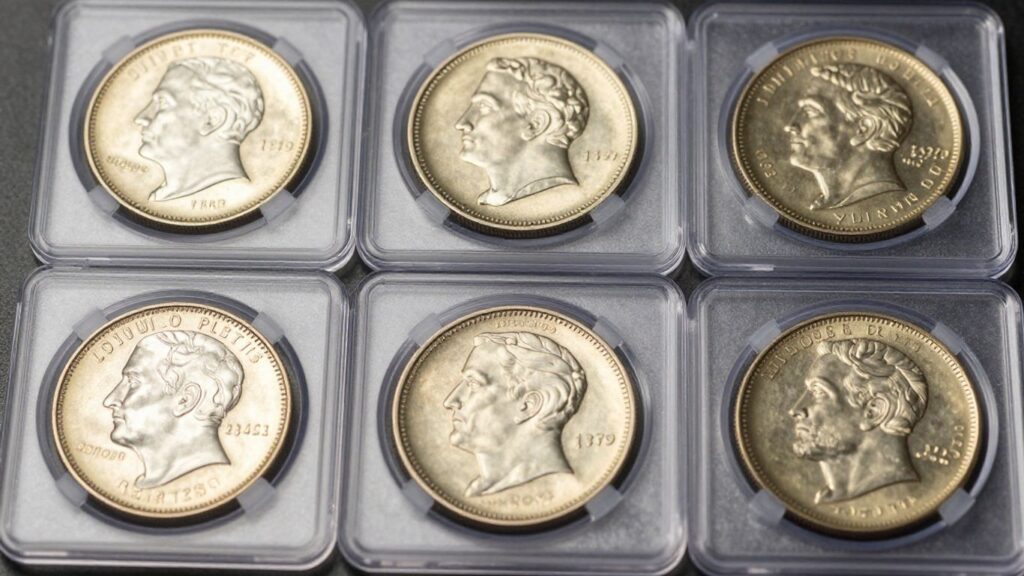 Graded coin slabs with visible coins inside.