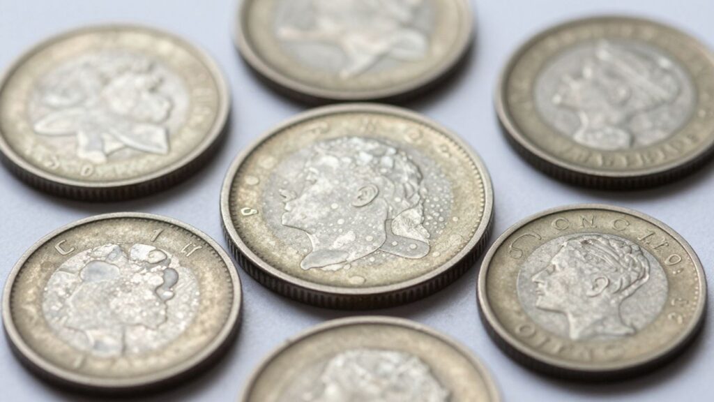 Close-up of coins with white spots.